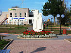Памятник основателю города — преподобному Лонгину, на заднем плане кедры.