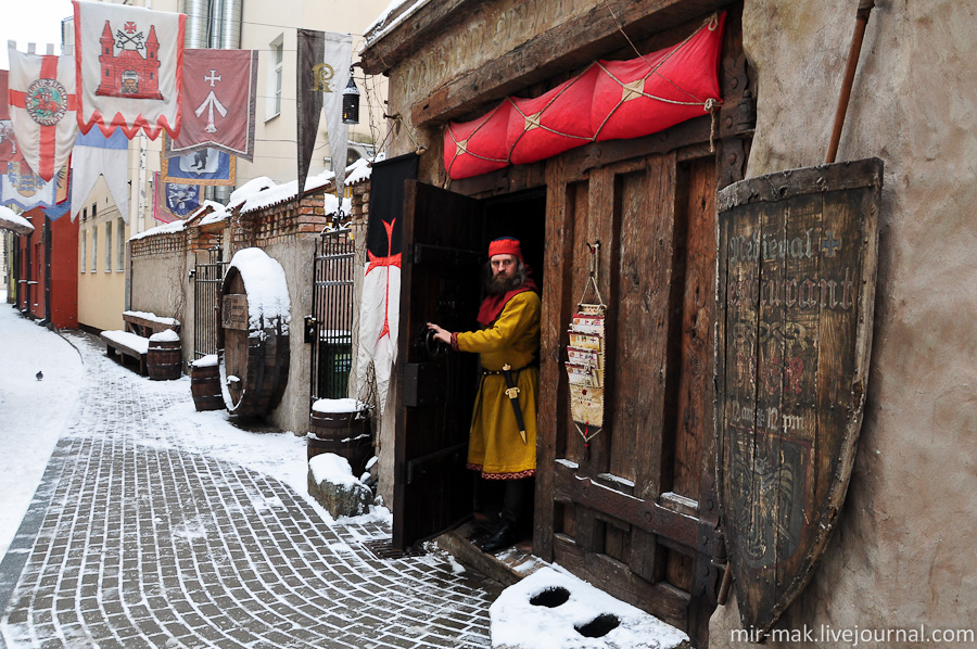 Средневековый ресторан, вход в который охраняет колоритный воин. Рига, Латвия