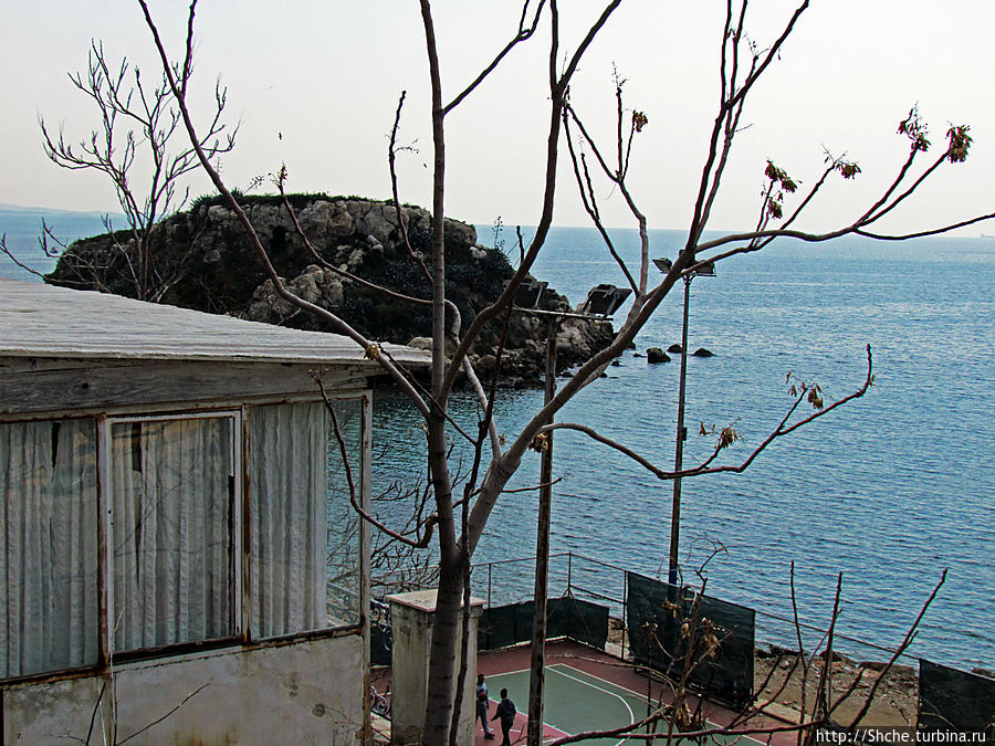 слева в море живописный камень-остров Пирей, Греция