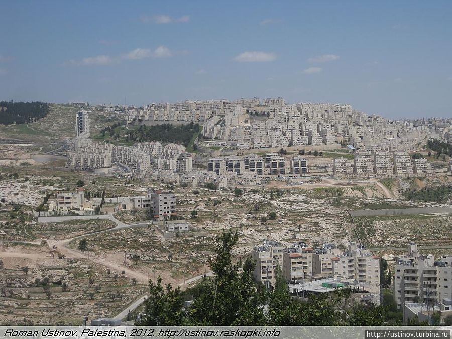 Вид на еврейский кибуц из-за палестинской стены Палестина