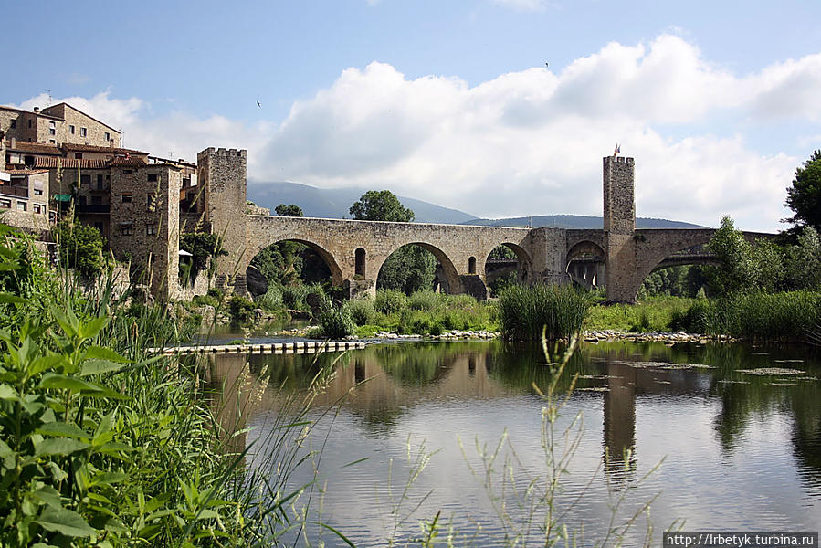 Старый романский мост Бесалу в летнем антураже Бесалу, Испания