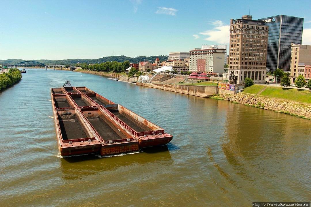 Угольные баржи, проплывающие по реке Канава (Kanawha river) в Чарльстоне, стали символом возрождающейся угледобычи и снижения безработицы. Чарлстон, CША