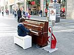 ... а другой тем, как сумел вытащить пианино на пешеходную зону. Хоть музыкант достаточно юный, но не забыл спрятать за музыкальным инструментом полиэтиленовый чехол на случай дождя.