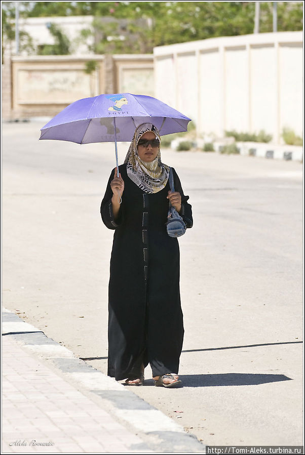 Колоритно — с зонтом под палящим солнцем. Здесь это — обычная картина. При плюс сорока на солнце. Эта дама даже не стала прятаться от фотокамеры. Хотя я чаще всего людей снимаю телевиком издалека...
* Каир, Египет