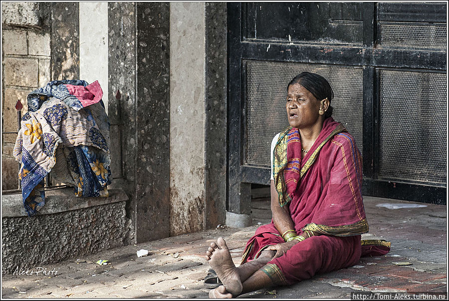У ворот богатого дома сидит запросто совсем бедная тетушка...
* Мумбаи, Индия