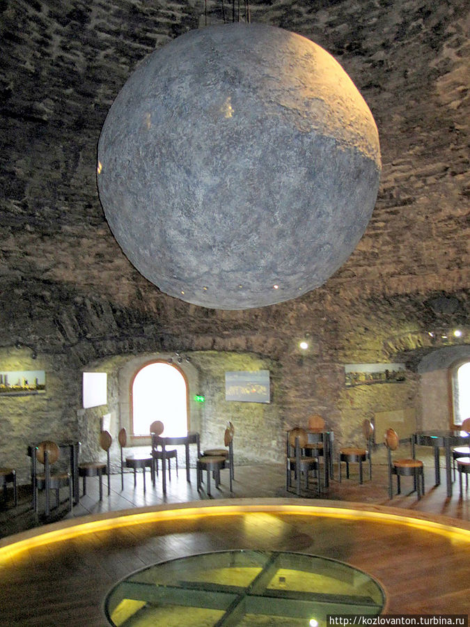 ...или подняться на самый верхний этаж, откуда и заглядывали когда-то в кухни. Но сейчас это совсем необязательно делать — здесь расположилось кафе. В центре зала — якобы каменный шар, выполняющий роль хронометра.