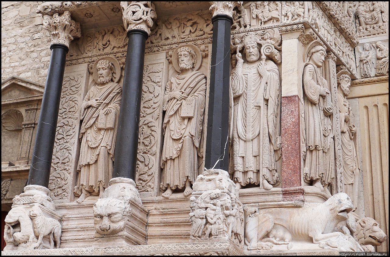 В левой стороне портала пять статуй изображают (слева направо) апостолов Варфоломея, Иакова Зеведеева, св. Трофима, апостолов Иоанна и Петра. Арль, Франция