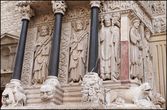 В левой стороне портала пять статуй изображают (слева направо) апостолов Варфоломея, Иакова Зеведеева, св. Трофима, апостолов Иоанна и Петра.