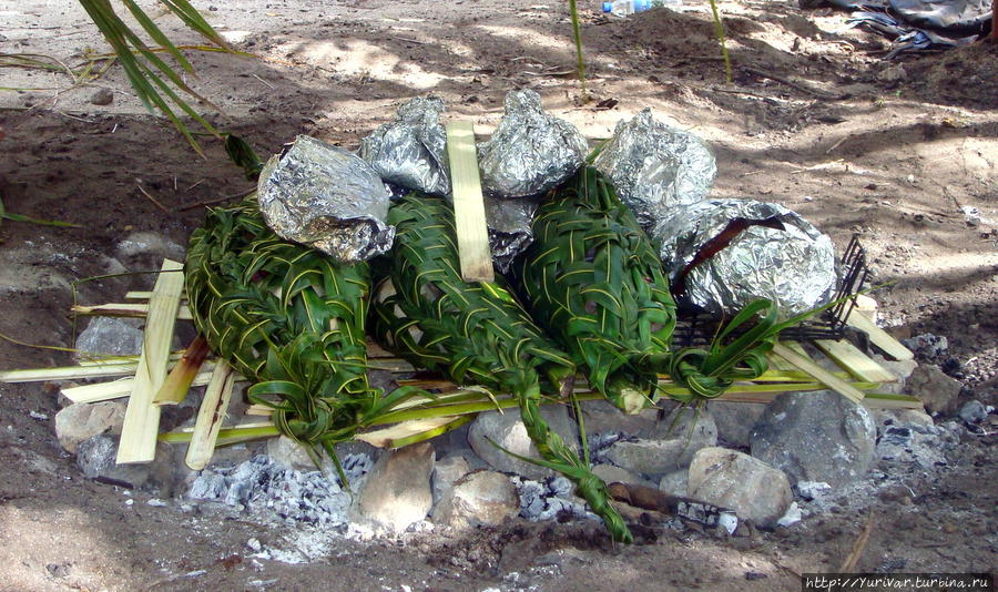 Теперь корзинки со снедью, положенные на пальмовые дощечки укроют тряпками и засыплют землей. Остров Дравака, Фиджи