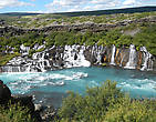 Этот водопад вытекает между слоями лавы, словно разрезая каменное плато.