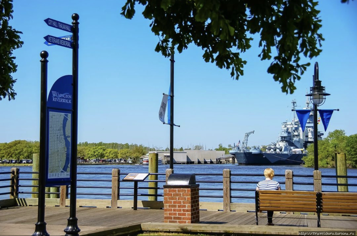 Набережная реки Кейп-Фир. На заднем плане виден корабль-музей USS North Carolina Уилмингтон, CША
