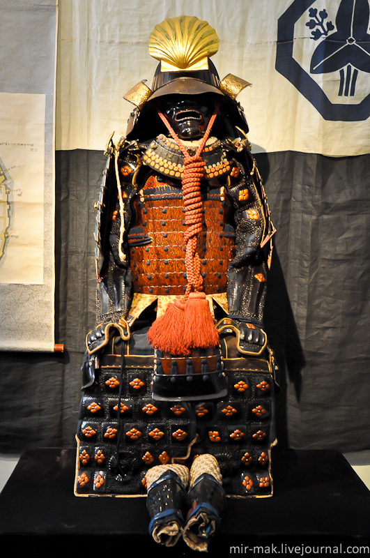 Доспех с кирасой декорированной в технике мокумэ-ганэ. Вторая половина 18 века.

Кираса этого доспеха декорирована элементами в технике мокумэ-ганэ. «Моку» значит «дерево», «мэ» — «глаз», «ганэ» — «металл». Обычно это название переводят как «деревянный глаз металла». Впервые ее использовали в 17 веке для декорирования оправы самурайских мечей.

Во время работы в этой технике мастер выковывает бруски из слоев металла, которые соединяются под давлением при высокой температуре. Такие бруски, составленные из различных комбинаций и сплавов золота, серебра и меди, проковывались, нарезались, и из них получались металлические пластины – каждая с уникальным рисунком, напоминающим структуру древесной коры. «Сэндвич» мокумэ может насчитывать до 30 и более разных по составу, оттенкам и толщине слоев.

В наши дни техника мокумэ-гане с некоторыми модификациями применяется в основном для создания необычайно красивых ювелирных украшений. Одесса, Украина