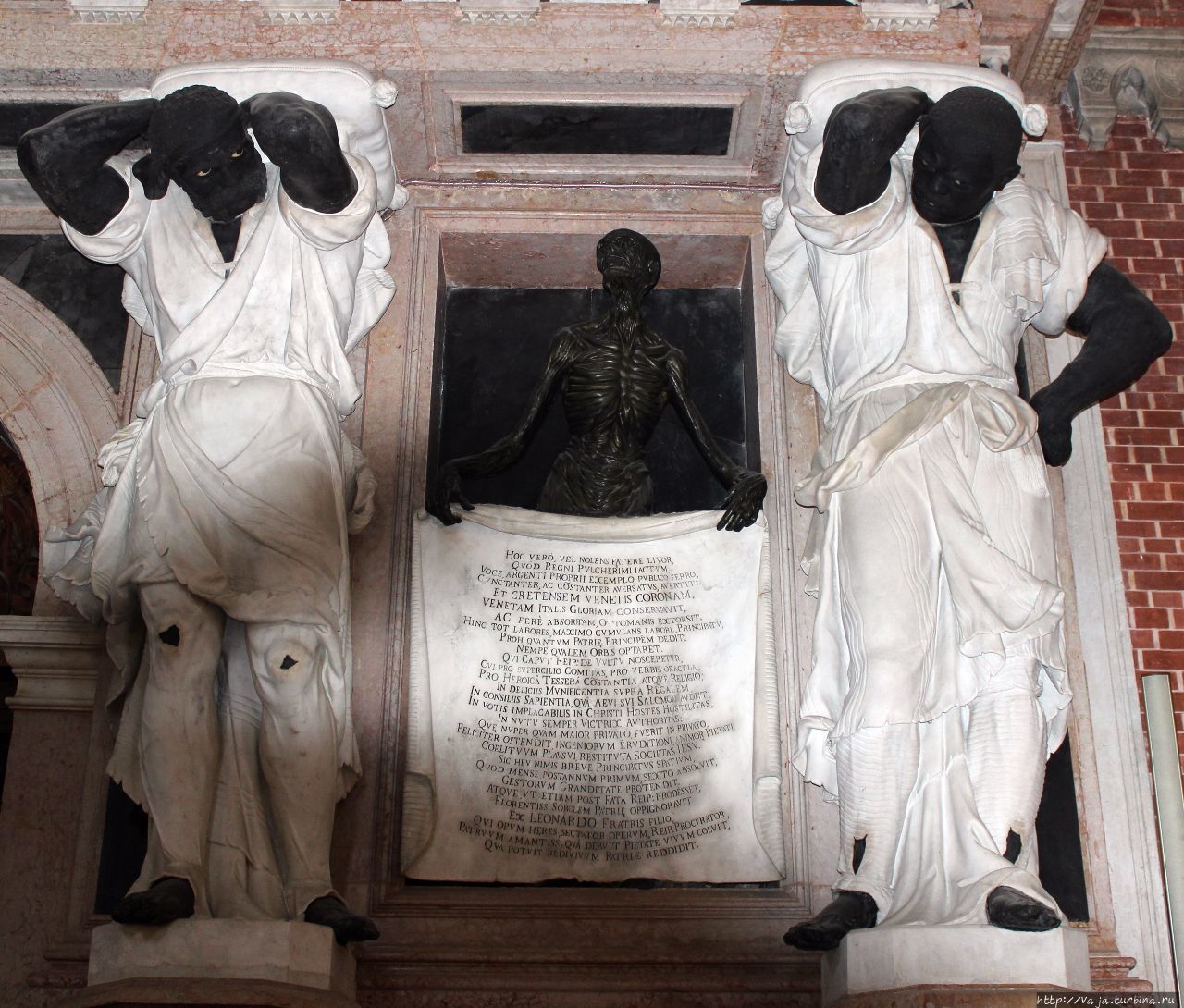 Статуи мавров антаблемент с трофеями,между ними расположены два панно со скелетами,держащими золоченный надписи. Это всё монументальный памятник дожу  Джованни Пезаро Венеция, Италия