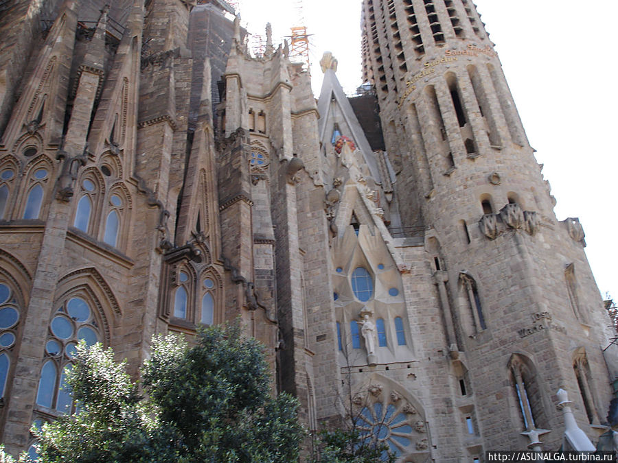 Храм Святого Семейства — это, пожалуй, самая знаменитая и посещаемая достопримечательность в Барселоне. И это более чем заслуженно! Саграда Фамилия выглядит не просто красиво, она выглядит величественно, волшебно и необычно.
Храм как будто бы сплетен из паутины или тончайшего кружева. Глядя на его фасад, трудно поверить, что это строение из камня, созданное руками человека.
Все благодаря множеству ниш, скульптур и узоров, которыми украшена конструкция.