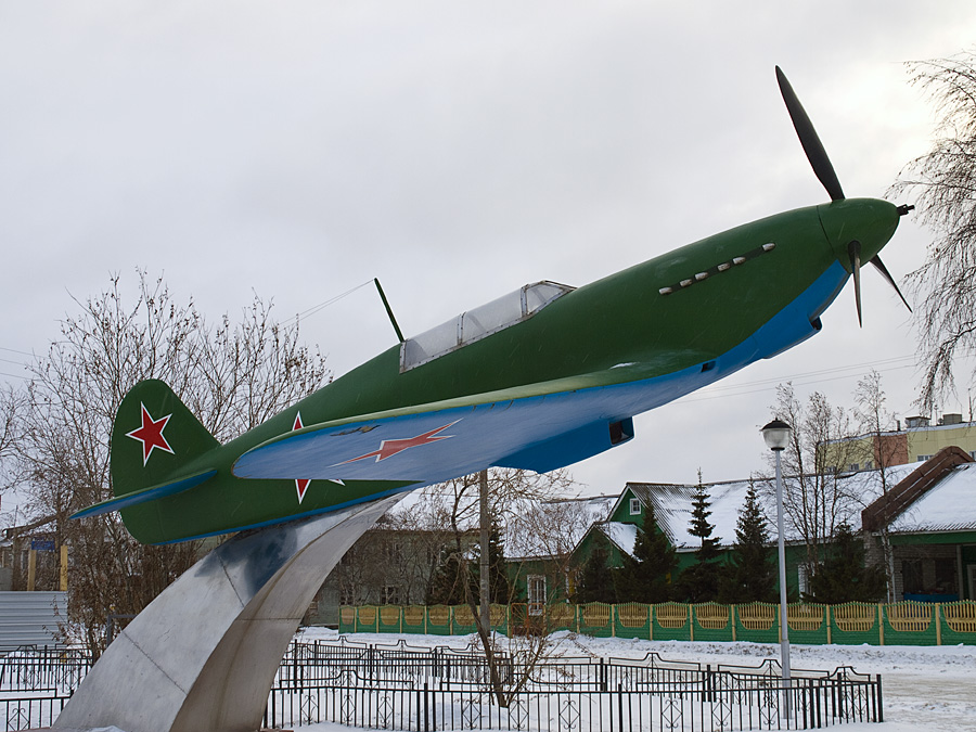 Мемориал в виде боевого аэроплана времен Второй Мировой войны (1939-1945 гг.) Яковлев-7Б. Мемориал представляет собой современную реконструкцию старого аэроплана с использованием оригинальных деталей от разных экземпляров этой серии. Установлен в память о боевой единице, купленной у военной промышленности СССР на деньги, собранные местными жителями во время Второй Мировой войны и переданной в одну из боевых частей на советско-германском фронте. Нынешний памятник поставлен в 1990-е годы — он уже второй по счету такой на данном месте — первый был сооружен практически сразу после окончания WW-II, но просуществовал недолго, будучи утрачен при неясных обстоятельствах. Нарьян-Мар, Россия