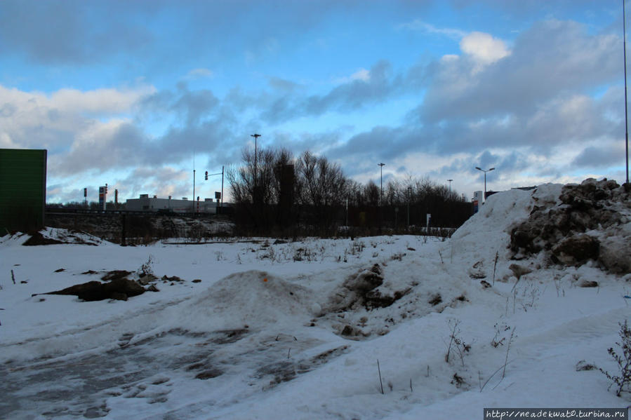 Вдали видна пром зона, а на переднем плане грязные сугробы снега с трассы Москва и Московская область, Россия