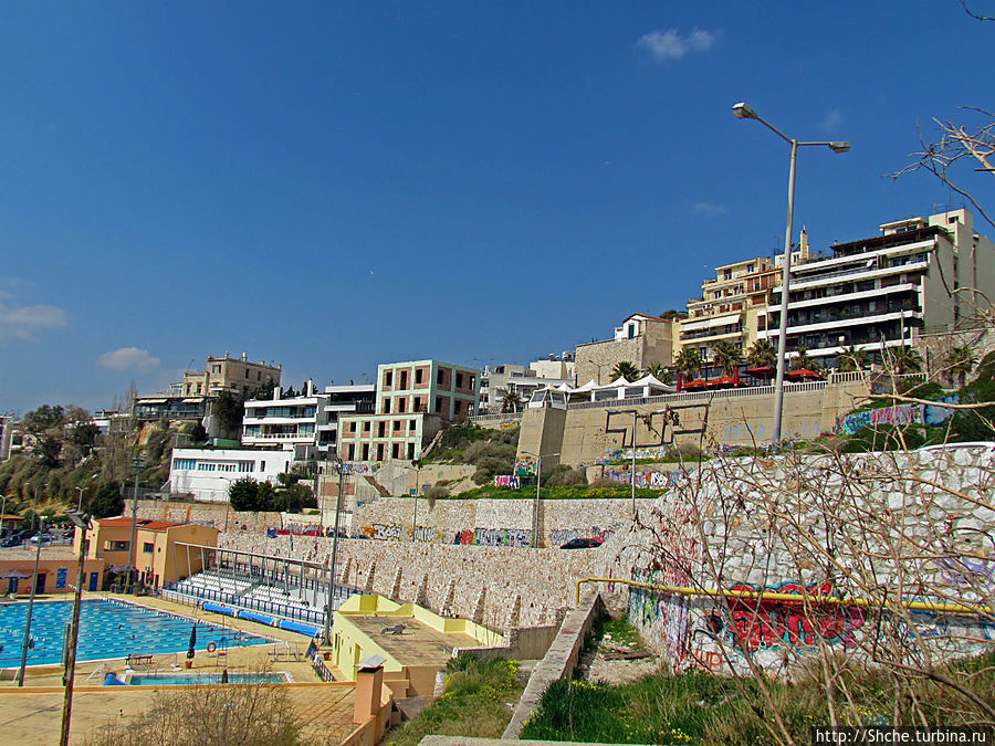 вдоль берега проступают ряды отелей Пирей, Греция