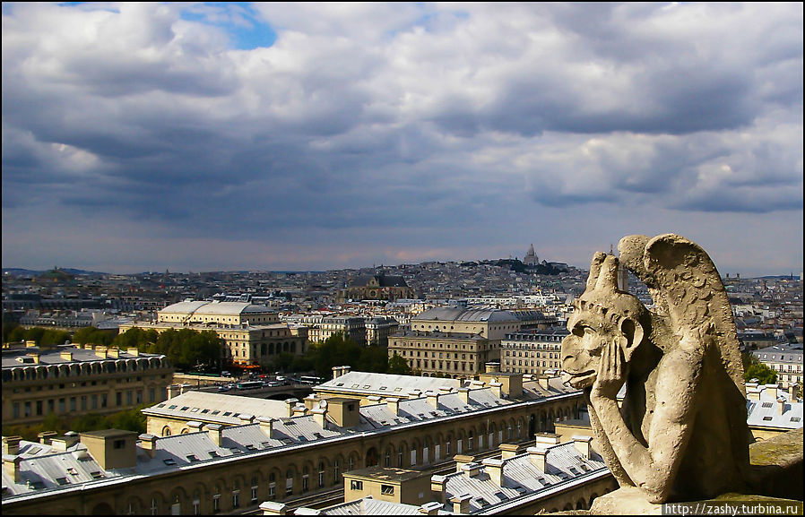 Каменные охранники на обзорной площадке собора Нотр-Дам, вдалеке видна возвышенность Монмартра Париж, Франция