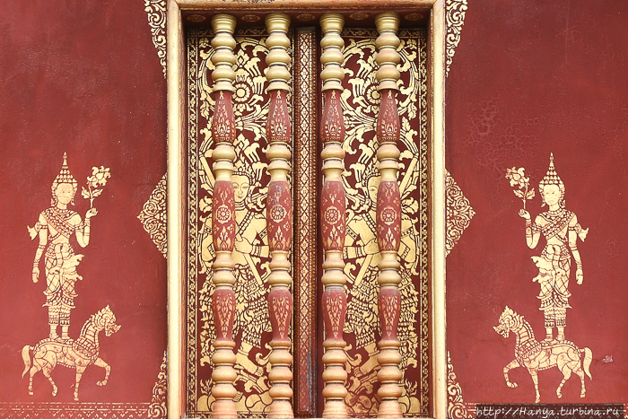 Храмовый комплекс Ват Сене Сук Харам. Здание Wat phra chao pet soc с трафаретными позолоченными стенами. с двух сторон каждого окна изображены божества, стоящие на льве или лошади и держащие в руке цветок лотоса. Фото из интернета