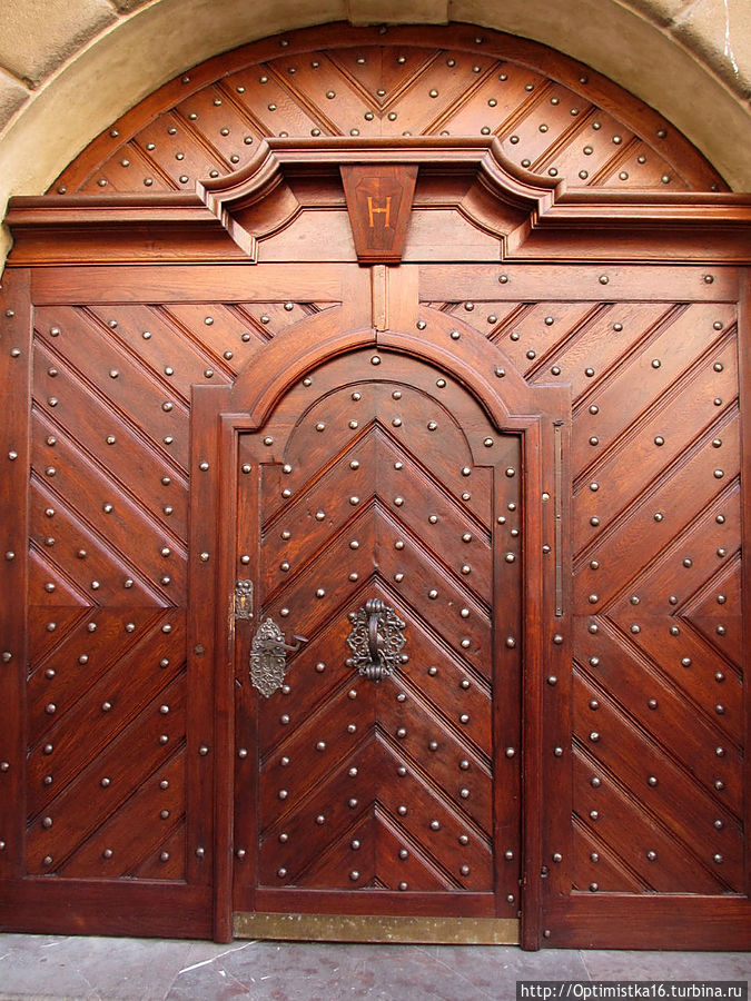 На воротах бывшей Градчанской ратуши в дверь вставлена узкая металлическая полоска.