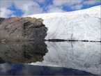 Ледник, перевалив через каменную гряду, отражается в небольшом озере